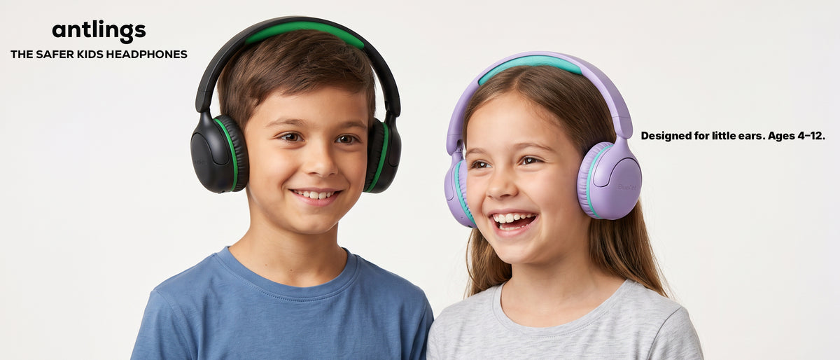 Two primary-school-aged children smiling while wearing BlueAnt Antlings wireless headphones
