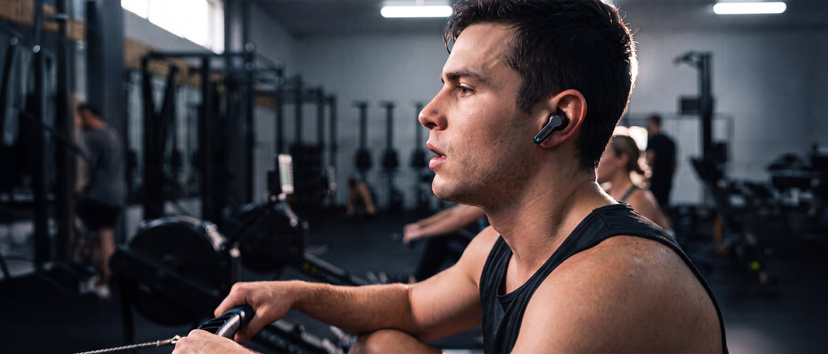 Man rowing at the gym wearing black BlueAnt Pump Air ANC 2 earbuds