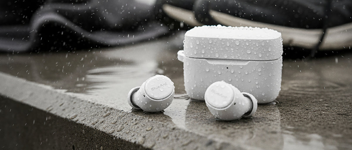 Water-resistant white BlueAnt Pump Air Lite 3 earbuds and case in the rain