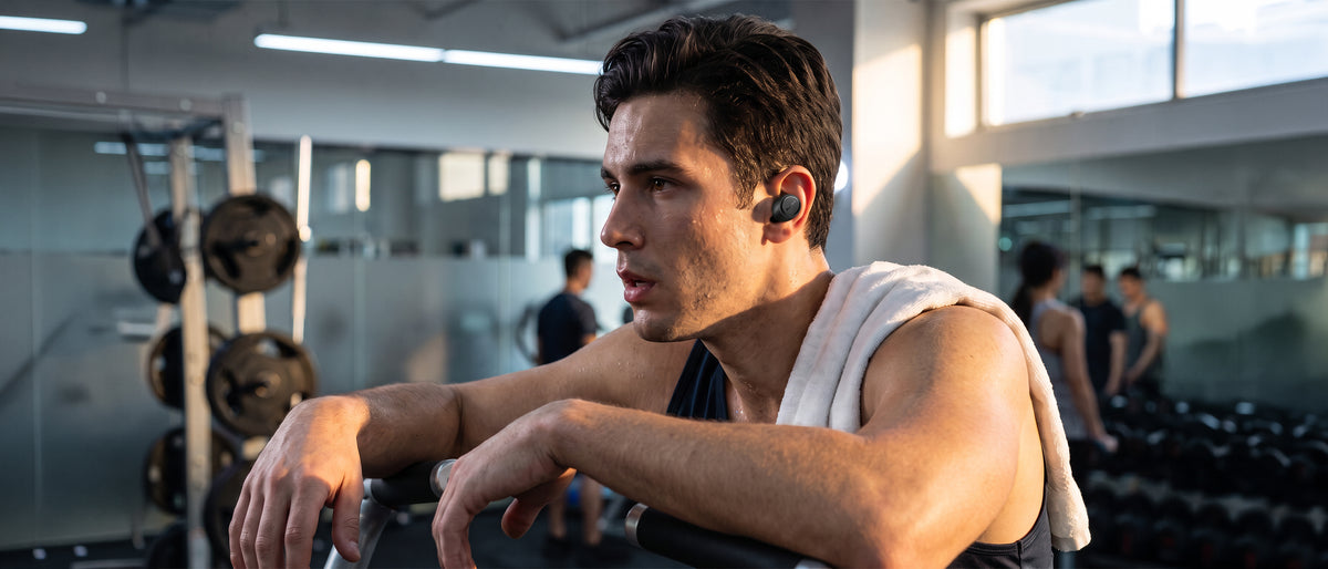 Man at the gym wearing BlueAnt Pump Air Lite 3 wireless earbuds