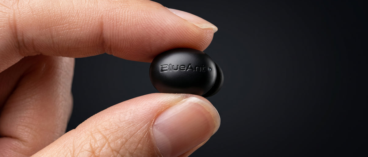 BlueAnt Pump Air Micro earbud held between finger and thumb, showing how small it is