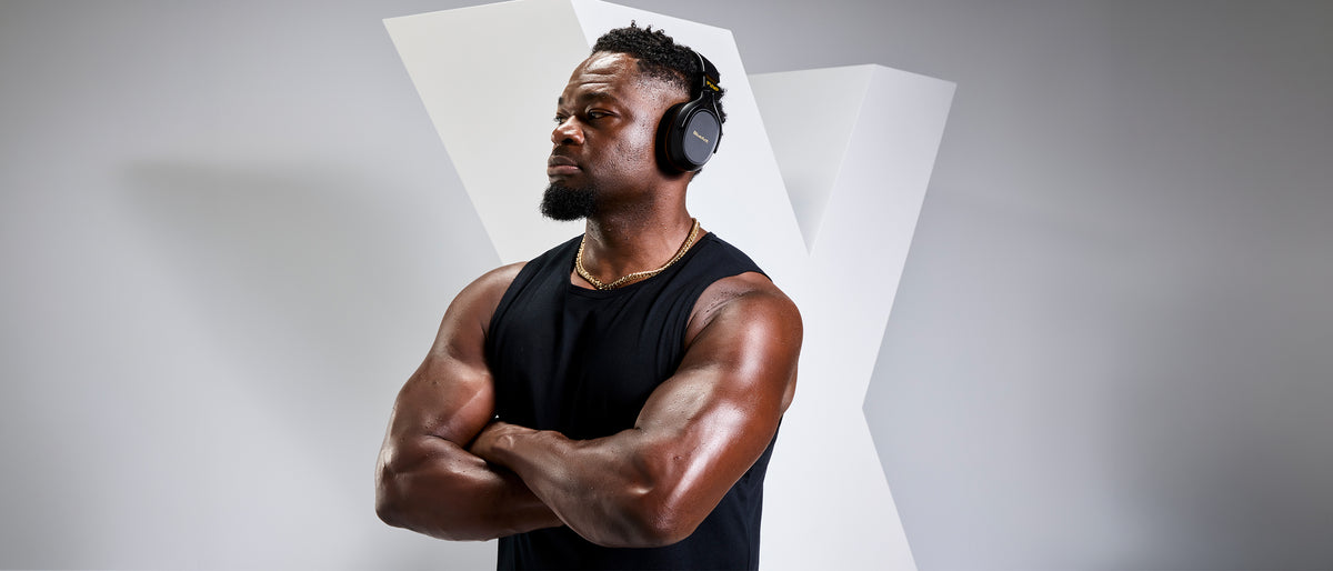Man wearing BlueAnt Pump X headphones in a gym studio setting