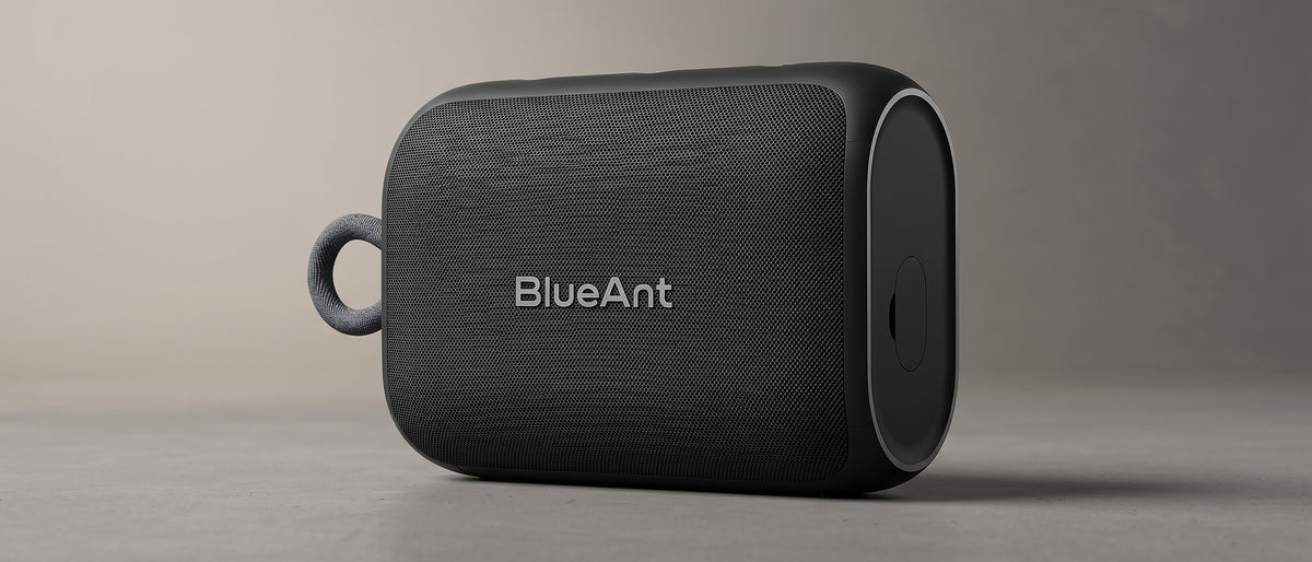 BlueAnt X0i speaker showing its woven grille, rounded rubber end cap and grey wrist loop