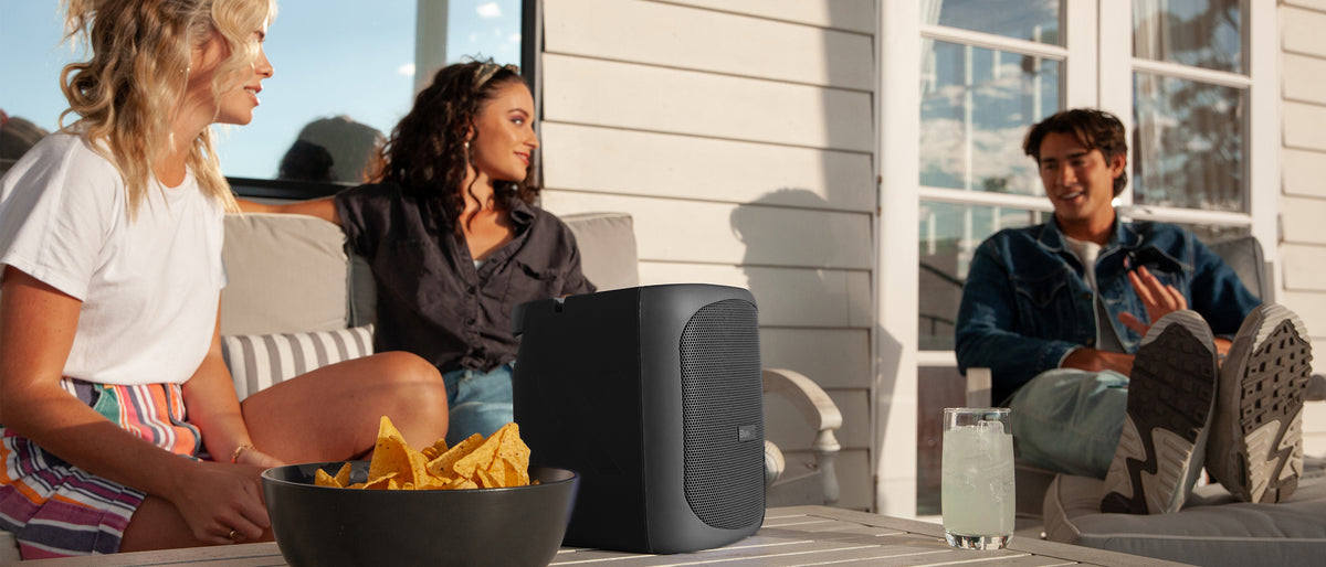 BlueAnt X4 speaker playing on a sunny verandah during a backyard get-together